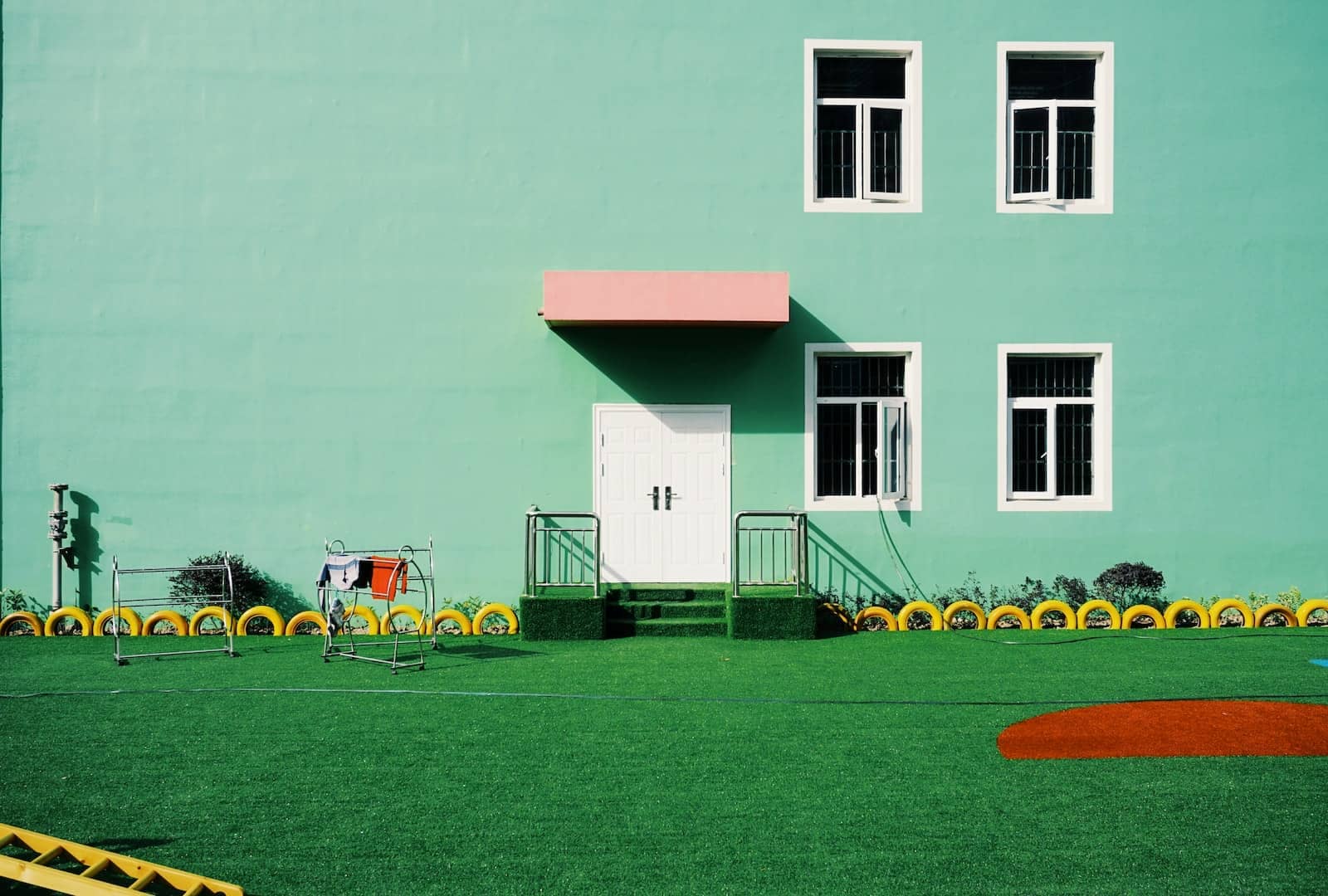 green painted building beside lawn
